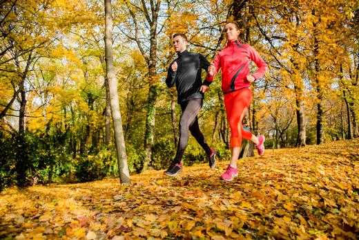 5 tips to stay fit this fall with a woman and man running outside